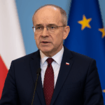 Polens Vize-Verteidigungsminister Pawel Zalewski bei einer Pressekonferenz. Im Hintergrund sind die Flaggen von Polen und der Europäischen Union zu sehen. Zalewski spricht über Polens Wunsch nach mehr militärischer Verantwortung und engerer Zusammenarbeit mit Europa und Deutschland.