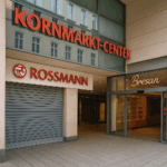 Eingang des Kornmarkt-Centers in Bautzen mit geschlossener Rossmann-Filiale und leerer Bäckerei Bresan. Deutlich sichtbare rote Beschriftung ‚Kornmarkt-Center‘ und Logos der Geschäfte. Das Bild zeigt die Schließungen im Center.