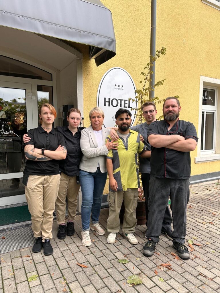 junger Mann in Hoteluniform blickt auf einen amtlichen Bescheid