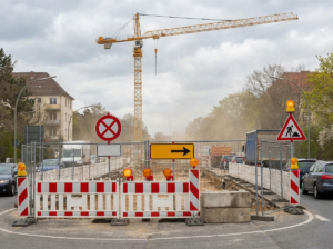 Symbolbild einer Straßensperrung mit Baustellenabsperrung und Verkehrsschild