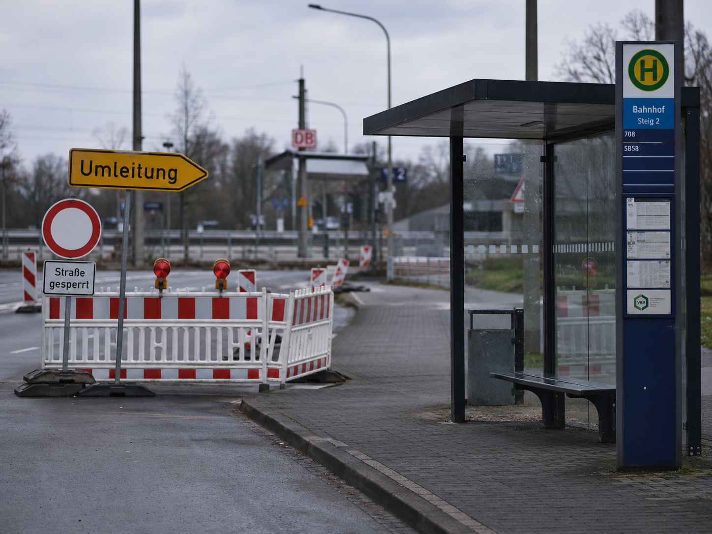 Symbolbild zur Sperrung der Bahnhofstraße in Zittau mit deutscher Bushaltestelle, Umleitungsschild und Baustellenabsperrung